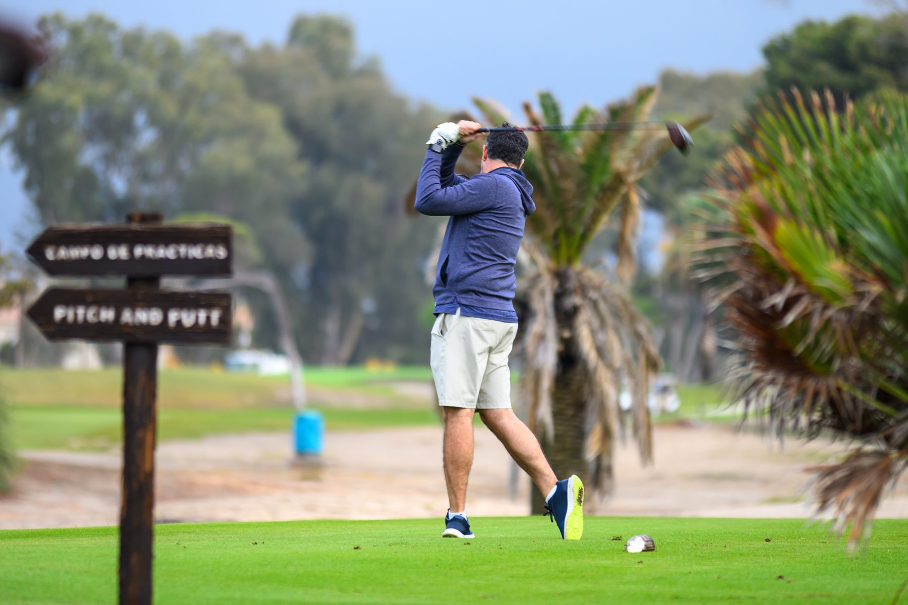 Jugador golpeando la bola en un torneo de golf de empresa