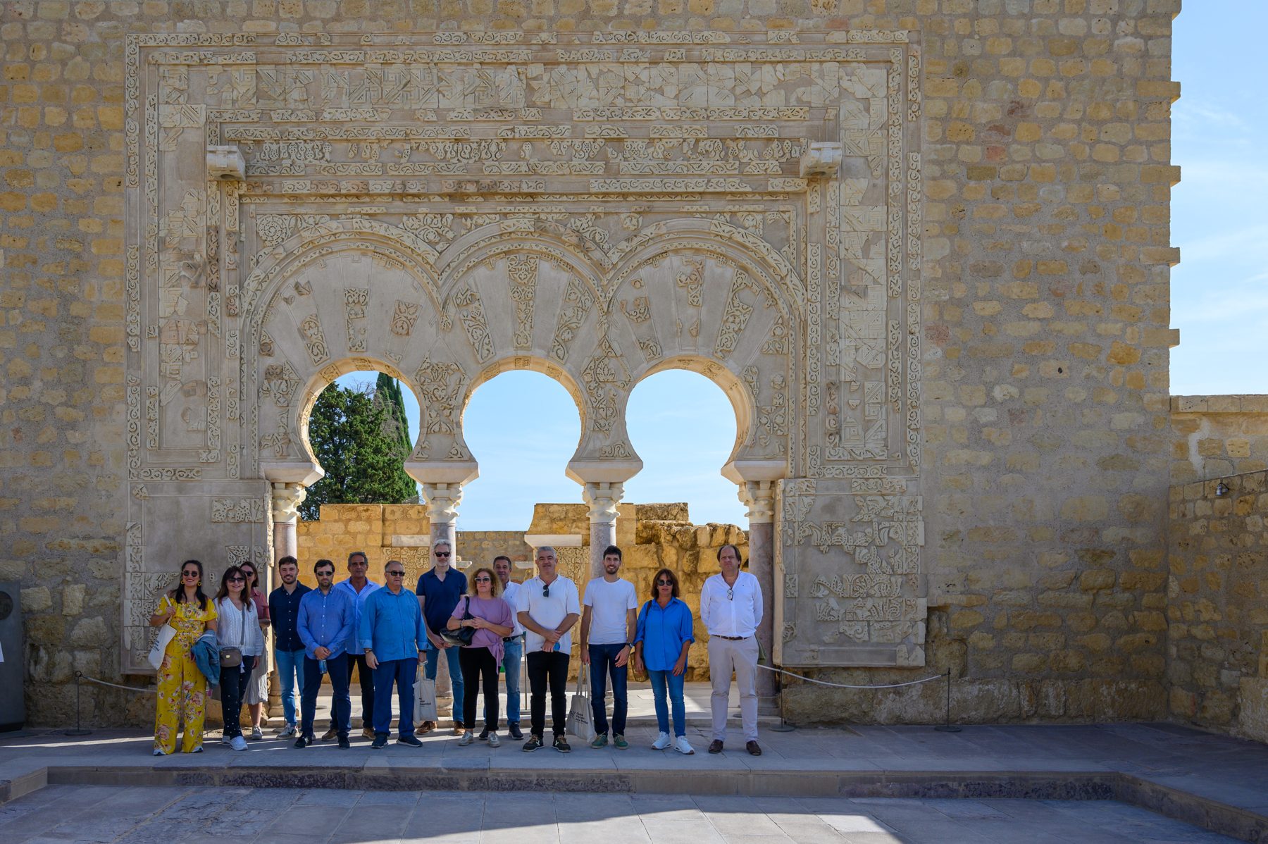 Foto de grupo de los asistentes a un congreso ante los arcos de Medina Azahara, Córdoba