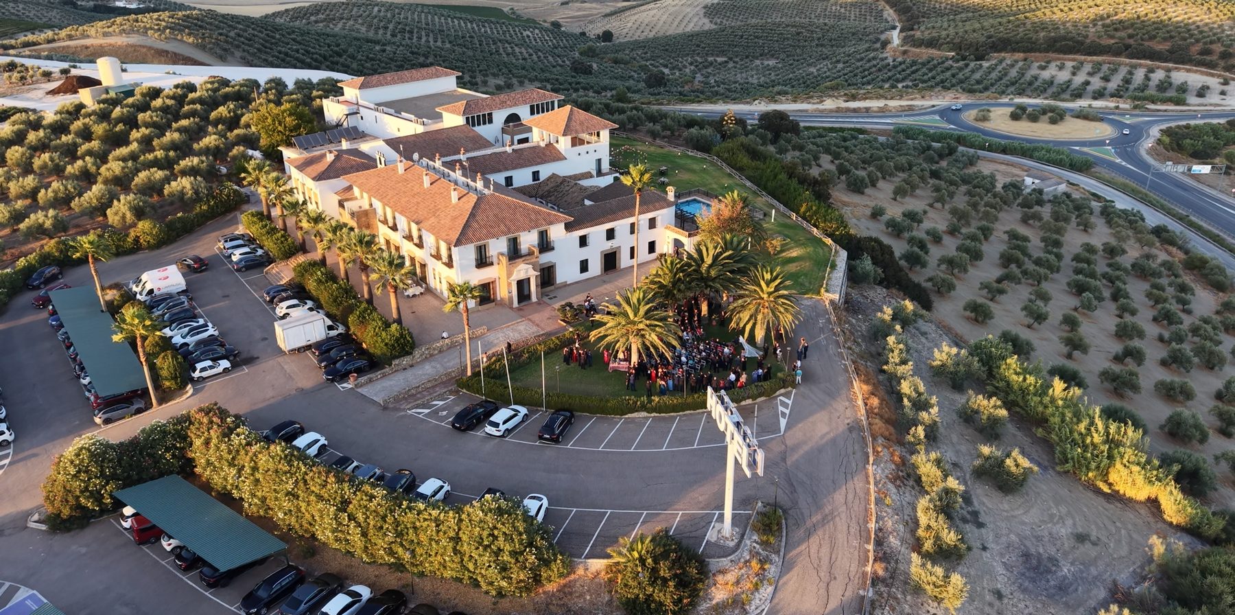 Vista aérea con dron de un cortijo-hotel rodeado de olivares al atardecer