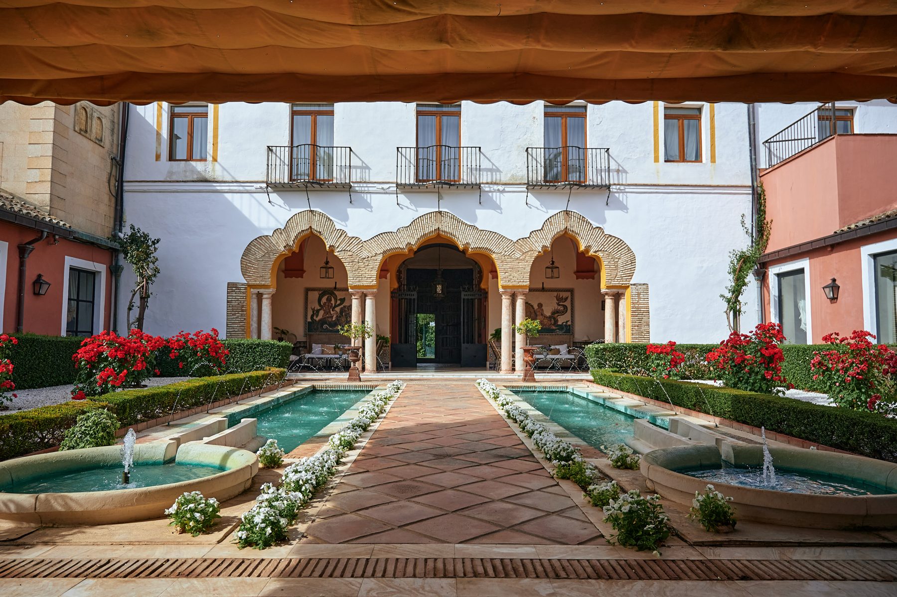Patio de hacienda con arcos, fuentes y jardín
