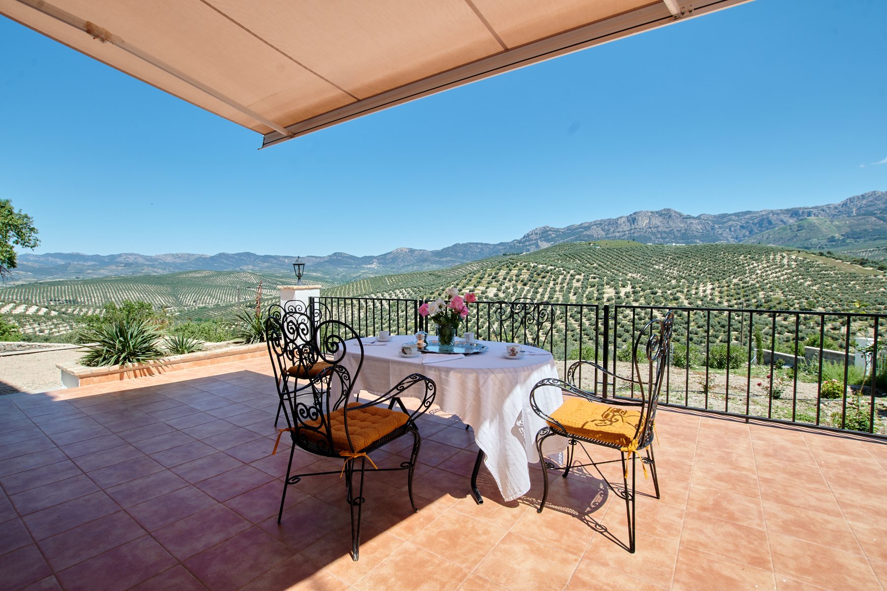 Terraza con toldo, mesa y vistas a la sierra y los olivares
