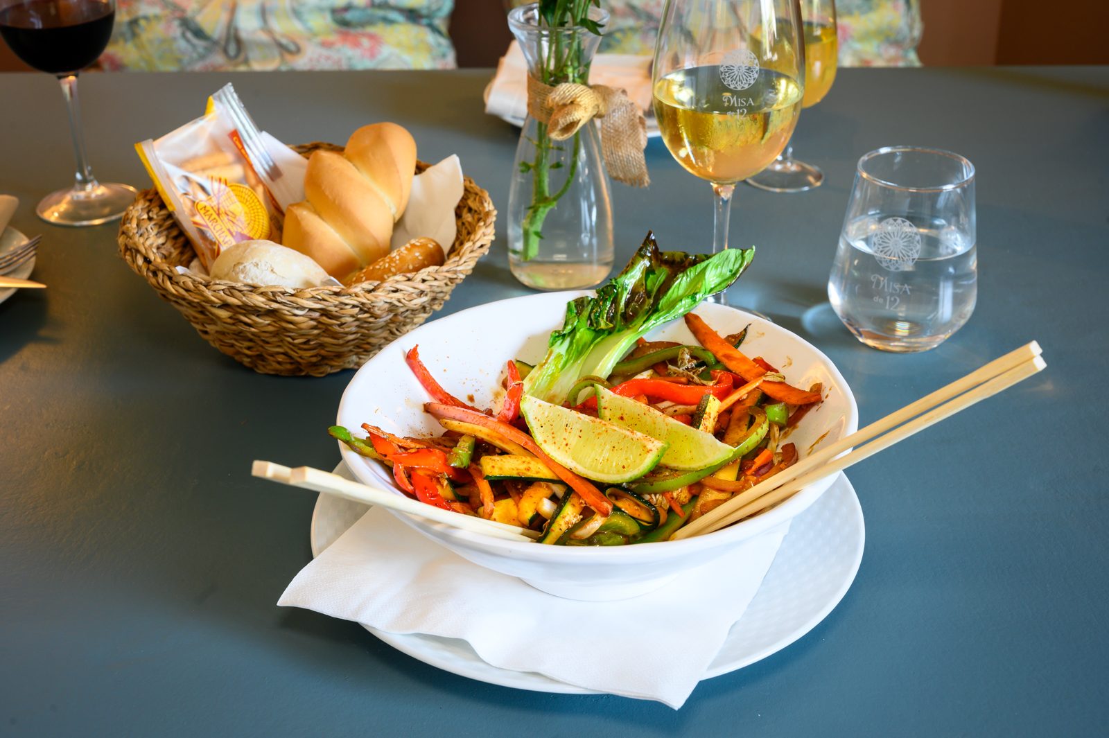 Wok de verduras con lima servido en mesa de restaurante